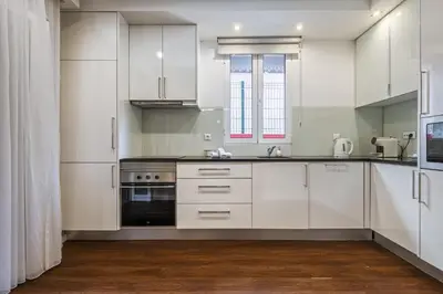 a kitchen with white cabinets and a black oven at Quinta da Tia Briosa by Homie in Ponta do Sol