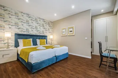 a bedroom with a king sized bed and a table at Quinta da Tia Briosa by Homie in Ponta do Sol