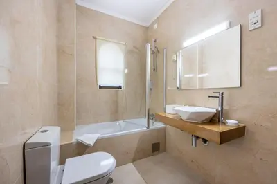 a bathroom with a toilet and a sink and a tub at Salema Beach Hotel in Salema