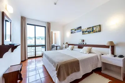 a bedroom with a bed and a large window at Salema Beach Hotel in Salema