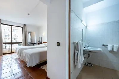 a bedroom with a large white bed and a television at Salema Beach Hotel in Salema