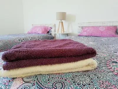 a pile of blankets sitting on top of a bed at Blacksheep Sagres Guesthouse & Surf in Sagres