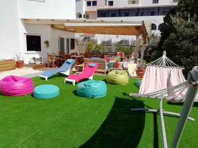 a yard with colorful chairs on the grass at Blacksheep Sagres Guesthouse & Surf in Sagres
