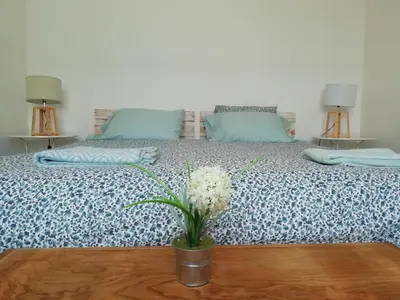 a bedroom with a bed with a vase of flowers on a table at Blacksheep Sagres Guesthouse & Surf in Sagres