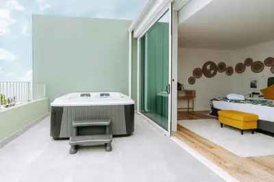 a bathroom with a bath tub and a bedroom at Hotel Euro Moniz in Porto Moniz