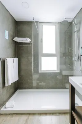 a bathroom with a shower and a glass shower stall at Hotel Euro Moniz in Porto Moniz