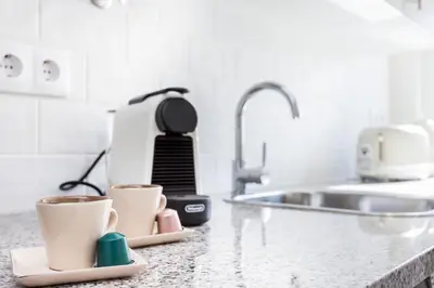 a kitchen counter with two cups of coffee at Casa da Vila in Vila do Bispo