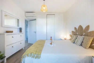 a bedroom with a bed with a bottle of wine on it at Casa da Vila in Vila do Bispo
