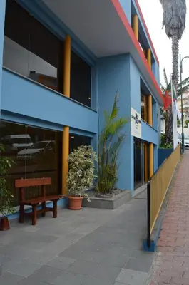 a blue building with a bench in front of it at Hotel Cais da Oliveira in Caniço