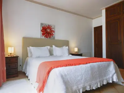 a bedroom with a large bed with a red blanket at Residencia Julio in Sagres