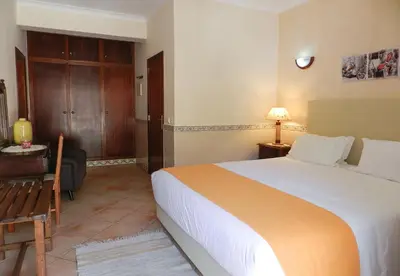 a hotel room with a large bed and a desk at Residencia Julio in Sagres