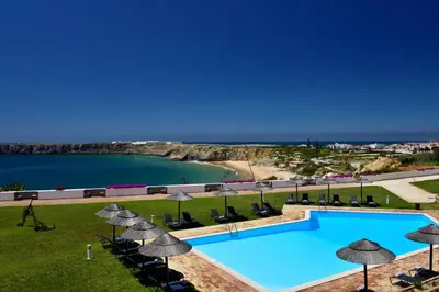 an aerial view of a swimming pool with chairs and umbrellas at Pousada de Sagres in Sagres