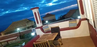 a balcony with a view of the ocean at night at the old school in Calheta