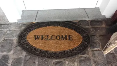 a sign that says welcome on a stone wall at the old school in Calheta