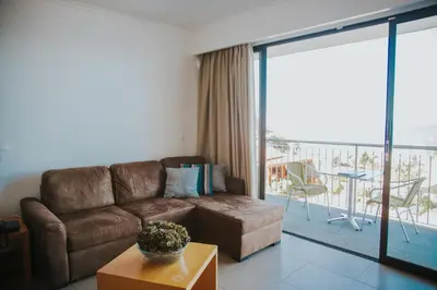 a living room with a couch and a balcony at Casa da Capelinha in Ponta Delgada