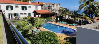 a swimming pool in front of a house at Casa da Capelinha in Ponta Delgada