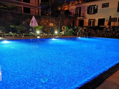 a large swimming pool at night with lights on at Casa da Capelinha in Ponta Delgada