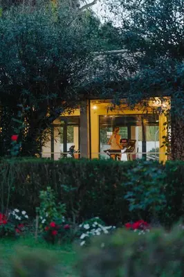 a woman sitting at a table in front of a house at Quinta da Bela Vista in Funchal