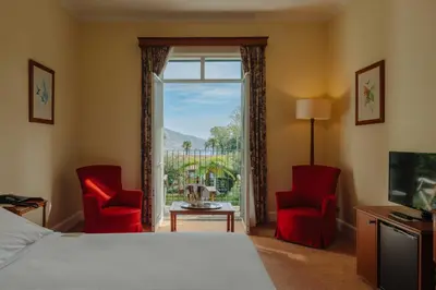 a hotel room with a bed and two chairs and a window at Quinta da Bela Vista in Funchal