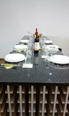 a table with plates and glasses and a bottle of wine at migs'place in Arco da Calheta
