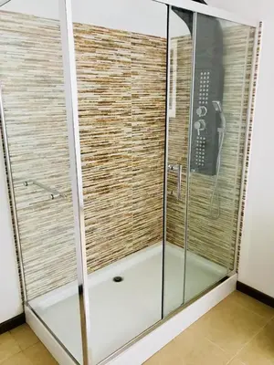 a shower with a glass enclosure in a bathroom at migs'place in Arco da Calheta