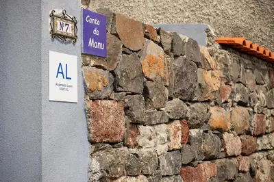 a stone wall with a sign on it at Canto da Manu Panoramic in Calheta