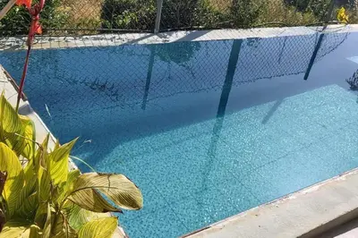 a fence around a swimming pool with a net at Canto da Manu Panoramic in Calheta