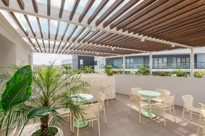 a restaurant with wooden tables and white chairs at Hotel Orquidea in Funchal