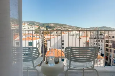 a hotel room with a large bed and a desk at Hotel Orquidea in Funchal