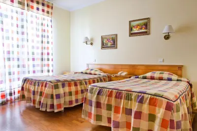 a hotel room with two beds in a room at Residencial Colombo in Funchal