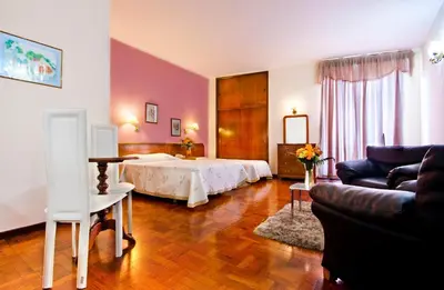 a bedroom with a bed and a couch and a table at Residencial Colombo in Funchal