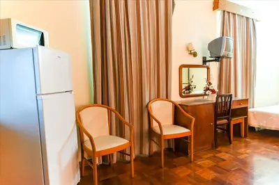 a kitchen with a refrigerator and a table and chairs at Residencial Colombo in Funchal