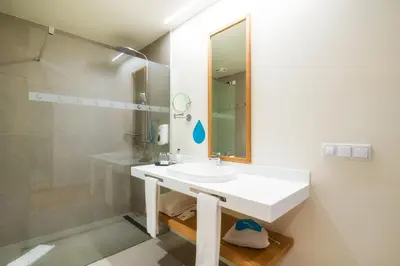 a bedroom with a large bed with a green headboard at Sentido Galomar - Adults Only in Caniço
