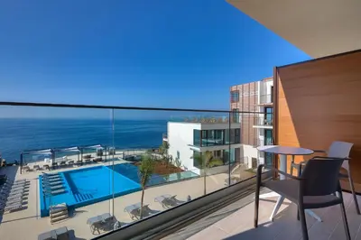 a view of a balcony with a swimming pool and the ocean at Sentido Galomar - Adults Only in Caniço