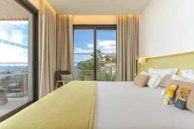 a living room with a yellow couch and a table at Sentido Galomar - Adults Only in Caniço