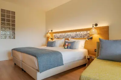 a hotel room with a large bed and a couch at Sentido Galosol in Caniço
