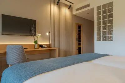 a bedroom with a bed and a desk with a television at Sentido Galosol in Caniço