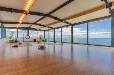 a large room with a wooden floor and large windows at Sentido Galosol in Caniço