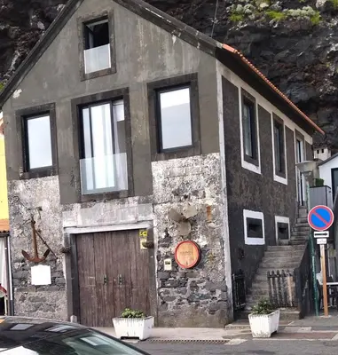an old stone building with a wooden door at Apartamentos Porto de Abrigo in São Vicente