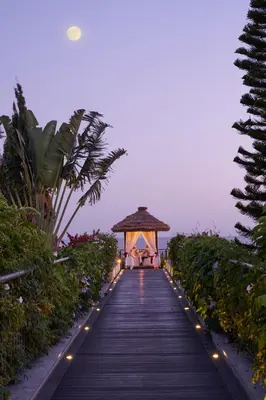 a boardwalk leading to a gazebo at a resort at Suite Hotel Eden Mar - PortoBay in Funchal