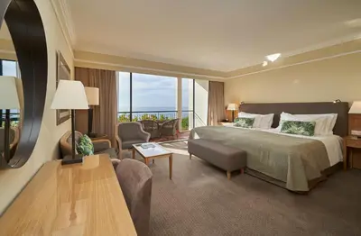 a hotel room with a bed and a large window at The Cliff Bay - PortoBay in Funchal