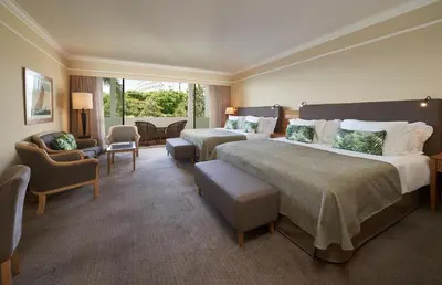 a hotel room with two beds and a living room at The Cliff Bay - PortoBay in Funchal
