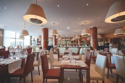 a restaurant with tables and chairs and a bar at Vila Gale Santa Cruz in Santa Cruz