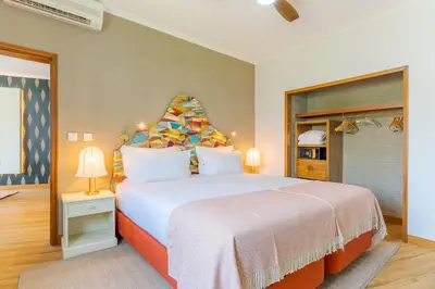 a bedroom with a large bed with a colorful headboard at Pestana Vila Lido Madeira Ocean Hotel in Funchal