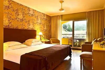 a hotel room with a bed and a balcony at Pestana Village Garden Hotel in Funchal