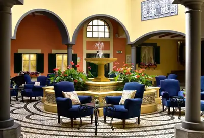 a lobby with chairs and a fountain in the middle at Pestana Village Garden Hotel in Funchal