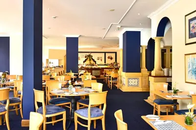 a restaurant with blue walls and tables and chairs at Pestana Village Garden Hotel in Funchal