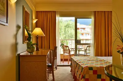 a hotel room with a bed and a balcony at Pestana Miramar Garden & Ocean Hotel in Funchal