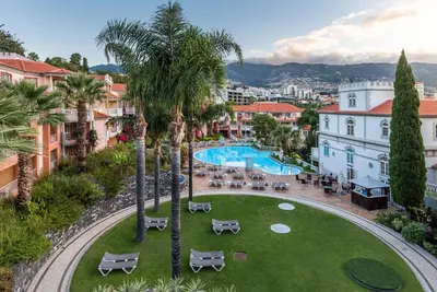 an aerial view of a park with a pool and palm trees at Pestana Miramar Garden & Ocean Hotel in Funchal