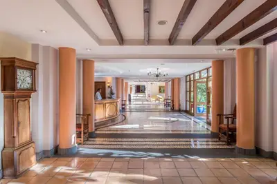 a hallway with orange columns and a clock in the middle at Pestana Miramar Garden & Ocean Hotel in Funchal